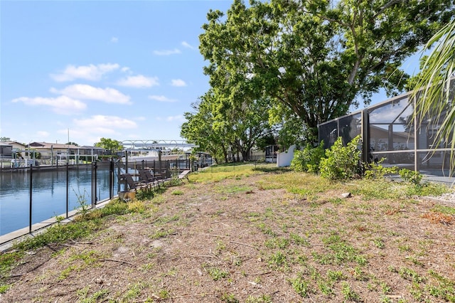 view of yard with a water view and glass enclosure