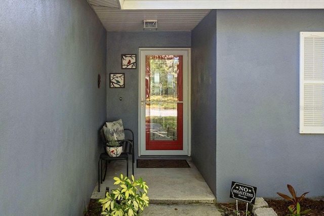 view of exterior entry with stucco siding