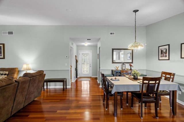 dining area featuring visible vents, baseboards, wood finished floors, and an inviting chandelier