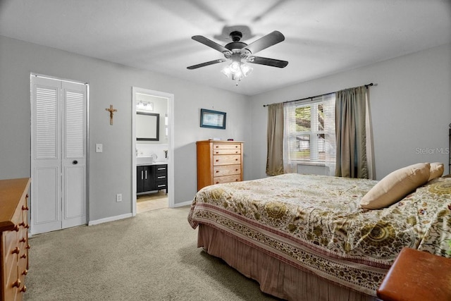 bedroom featuring a ceiling fan, baseboards, light carpet, and ensuite bathroom