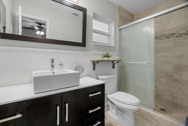 bathroom with vanity, ceiling fan, a stall shower, and toilet