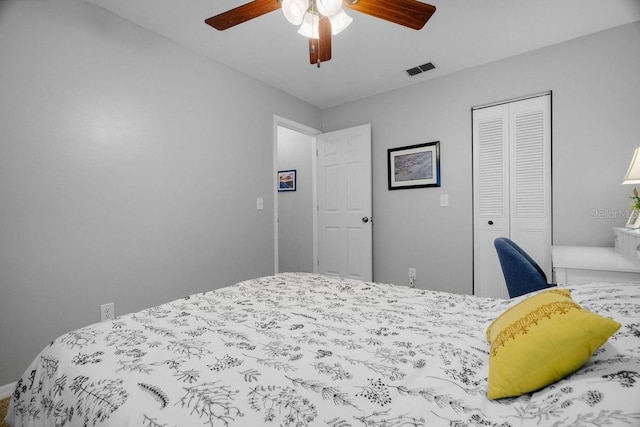 bedroom with ceiling fan, visible vents, baseboards, and a closet