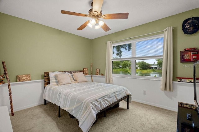 carpeted bedroom with a ceiling fan and baseboards