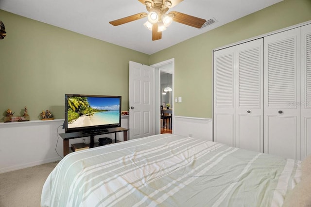 carpeted bedroom featuring ceiling fan, visible vents, baseboards, and a closet