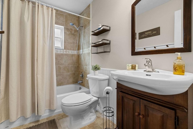 full bath featuring vanity, tile patterned flooring, wainscoting, shower / bath combination with curtain, and toilet