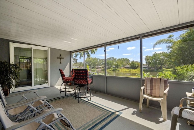 sunroom / solarium featuring a water view