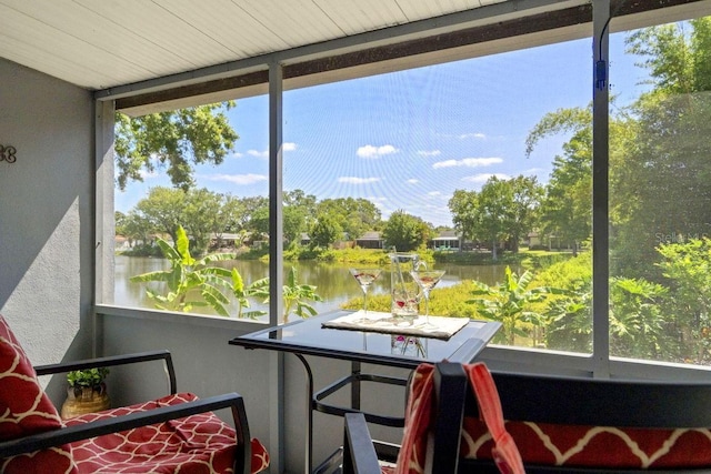 sunroom / solarium featuring a water view