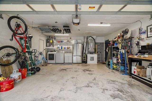 garage with freestanding refrigerator, heating unit, a garage door opener, and washer and dryer