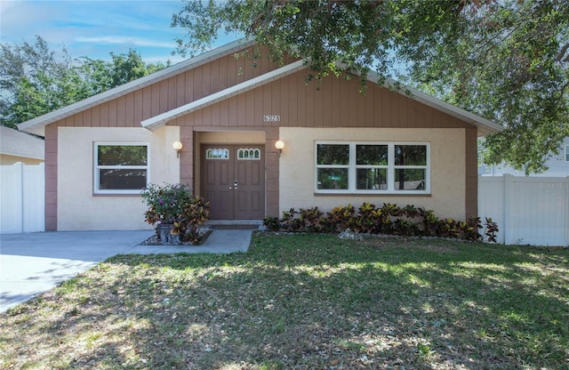 ranch-style home featuring fence and a front lawn