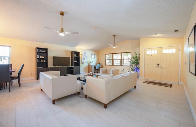 living room with a ceiling fan, visible vents, vaulted ceiling, and baseboards