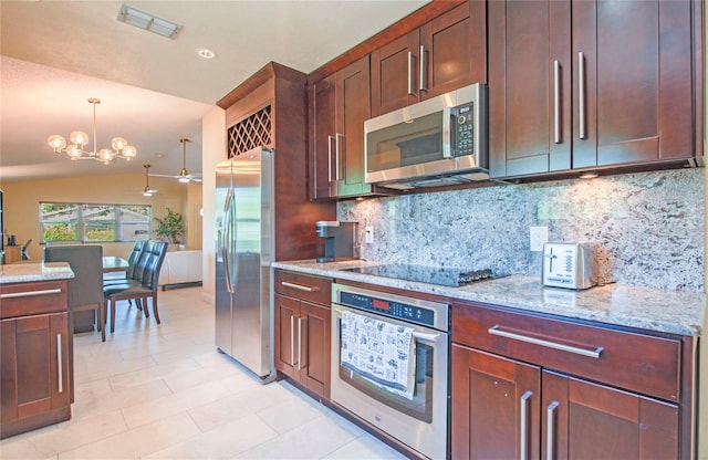 kitchen featuring tasteful backsplash, a chandelier, stainless steel appliances, decorative light fixtures, and vaulted ceiling