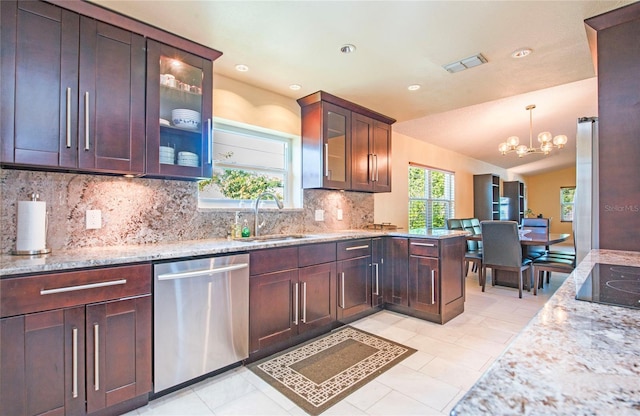 kitchen with decorative backsplash, a sink, visible vents, dishwasher, and a notable chandelier