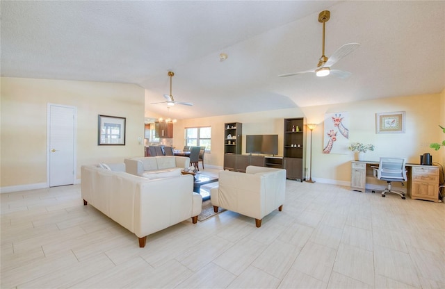 living area with baseboards, vaulted ceiling, and ceiling fan with notable chandelier