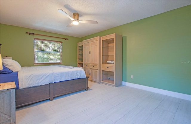 bedroom with baseboards, ceiling fan, and a textured ceiling