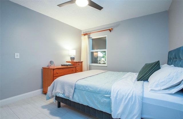 bedroom with a ceiling fan and baseboards