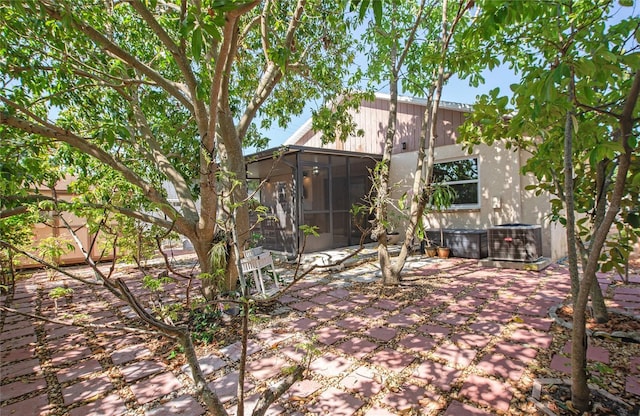 exterior space with cooling unit, a sunroom, and a patio