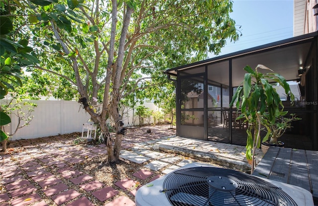 view of patio / terrace featuring a sunroom, a fenced backyard, and central AC unit