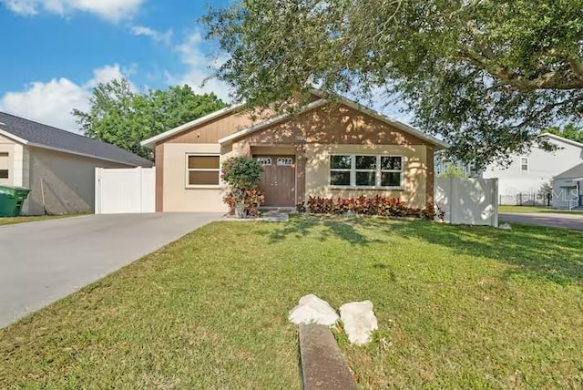 view of front facade featuring a front yard, driveway, and fence