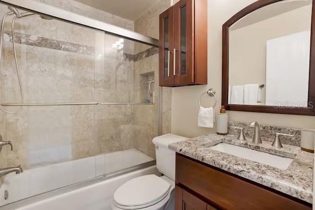 bathroom featuring shower / bath combination with glass door, toilet, and vanity