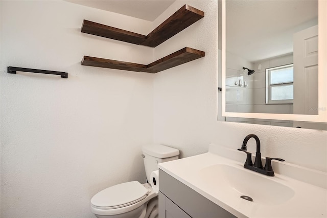 bathroom with toilet, walk in shower, and vanity
