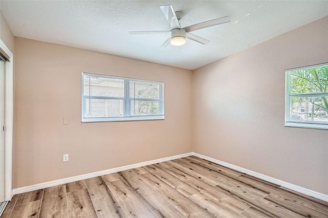 unfurnished room with baseboards, plenty of natural light, ceiling fan, and light wood-style floors