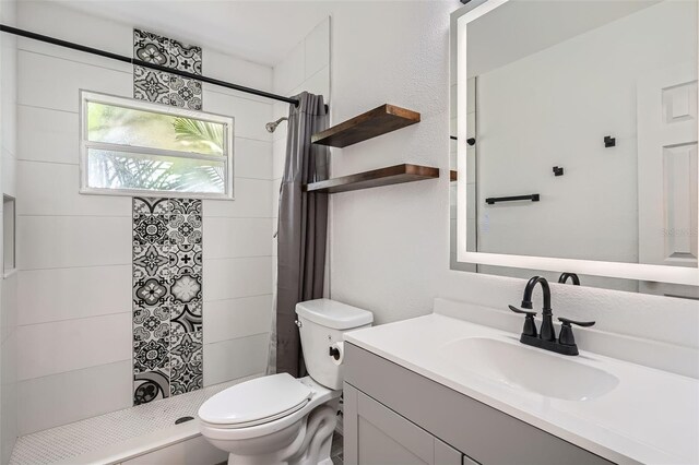 bathroom featuring vanity, toilet, and a shower stall