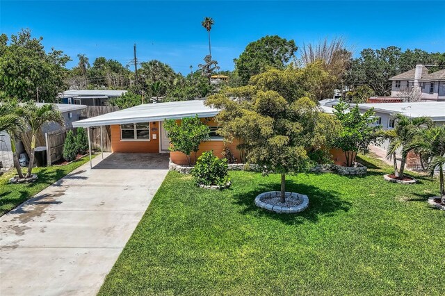view of front facade with a carport, driveway, and a front lawn