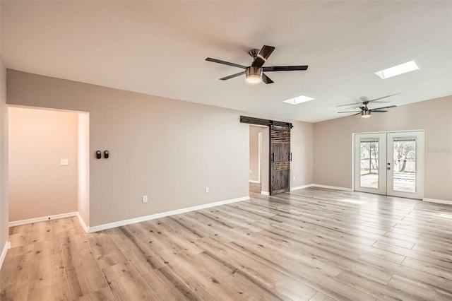 4018 Indianapolis St NE, Saint Petersburg, FL 33703 - empty room with a barn door, ceiling fan, a skylight, light wood-style floors, and baseboards