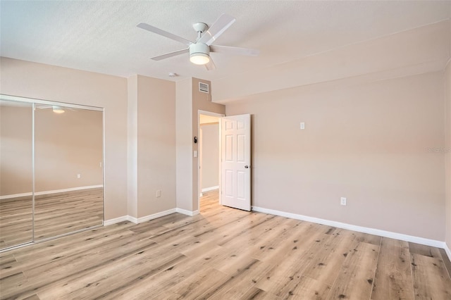 4018 Indianapolis St NE, Saint Petersburg, FL 33703 - unfurnished bedroom with light wood-style floors, a closet, baseboards, ceiling fan, and a textured ceiling