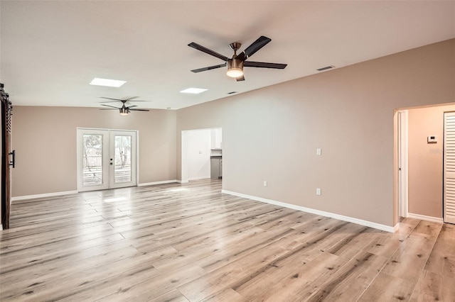 4018 Indianapolis St NE, Saint Petersburg, FL 33703 - unfurnished living room featuring a ceiling fan, a skylight, light wood finished floors, baseboards, and french doors