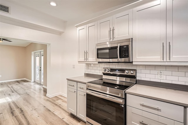 4018 Indianapolis St NE, Saint Petersburg, FL 33703 - kitchen featuring stainless steel appliances, decorative backsplash, light wood-type flooring, baseboards, and recessed lighting