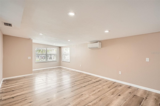 4018 Indianapolis St NE, Saint Petersburg, FL 33703 - unfurnished room with a wall mounted AC, light wood-style flooring, recessed lighting, baseboards, and vaulted ceiling