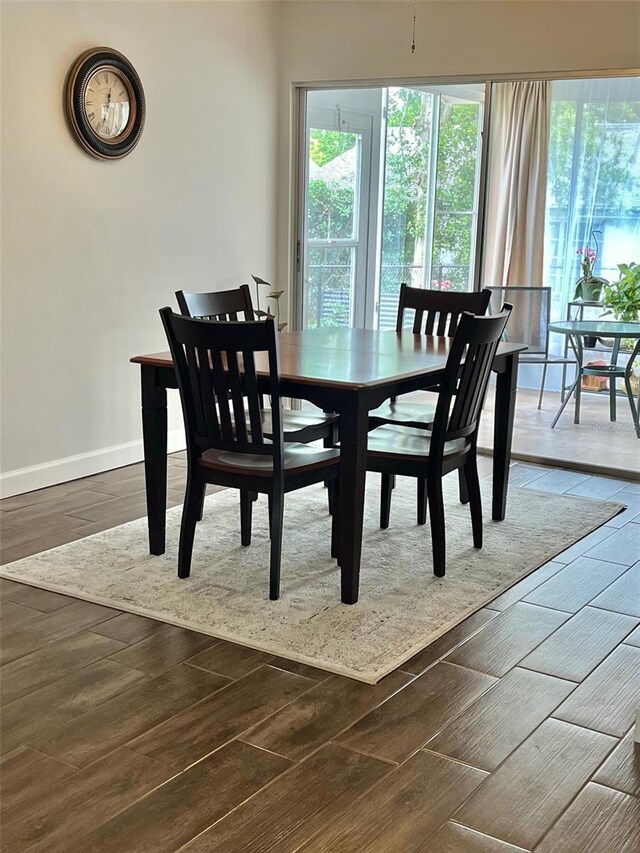 dining area with baseboards and dark wood finished floors