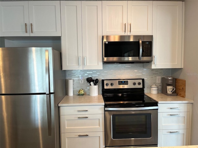 kitchen featuring backsplash, stainless steel appliances, and white cabinets
