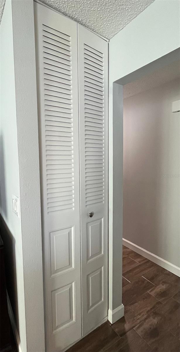 room details featuring a textured ceiling, baseboards, and wood finished floors