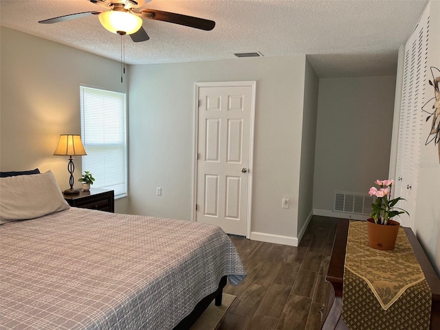bedroom featuring a textured ceiling, visible vents, and dark wood-style flooring