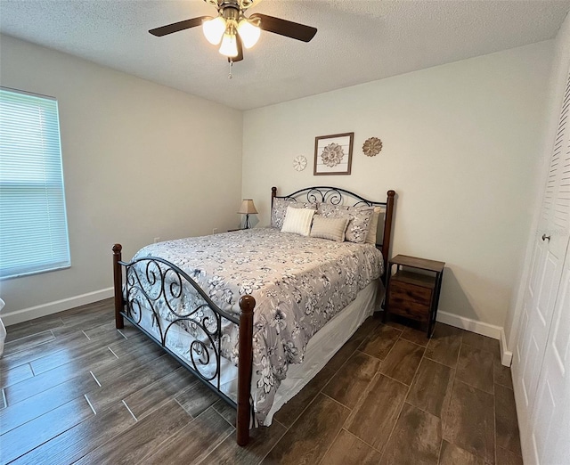 bedroom featuring baseboards, multiple windows, wood tiled floor, and ceiling fan