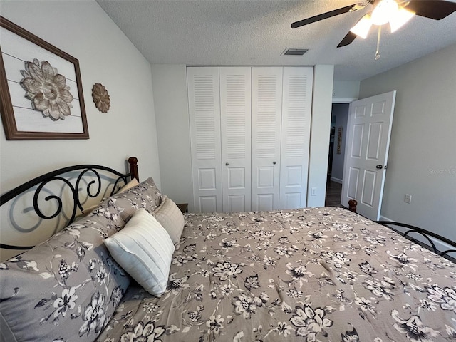 bedroom featuring ceiling fan, a textured ceiling, a closet, and visible vents