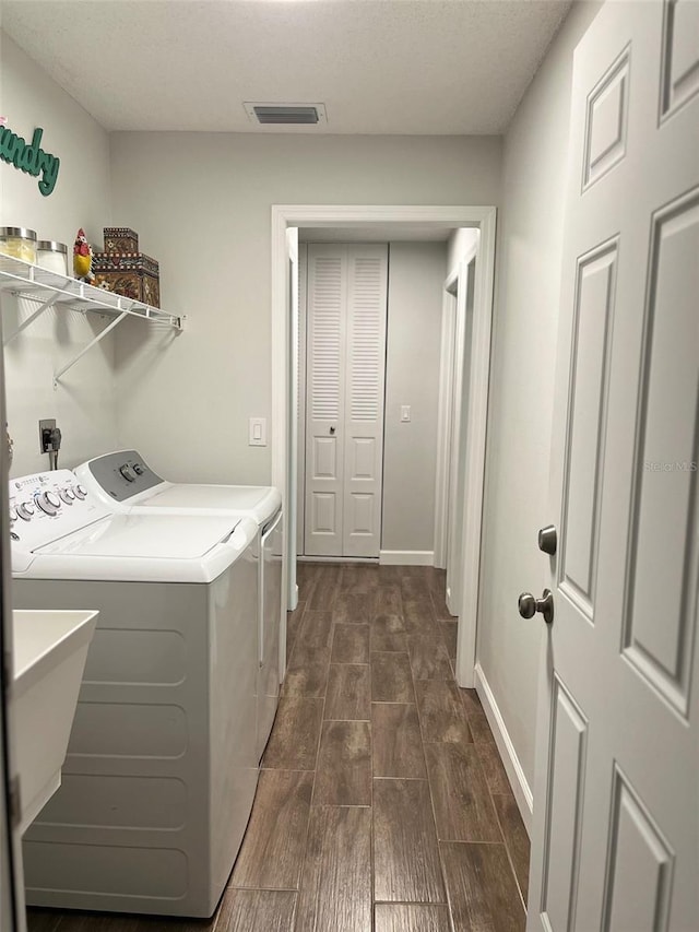 laundry room featuring a sink, independent washer and dryer, laundry area, visible vents, and wood tiled floor