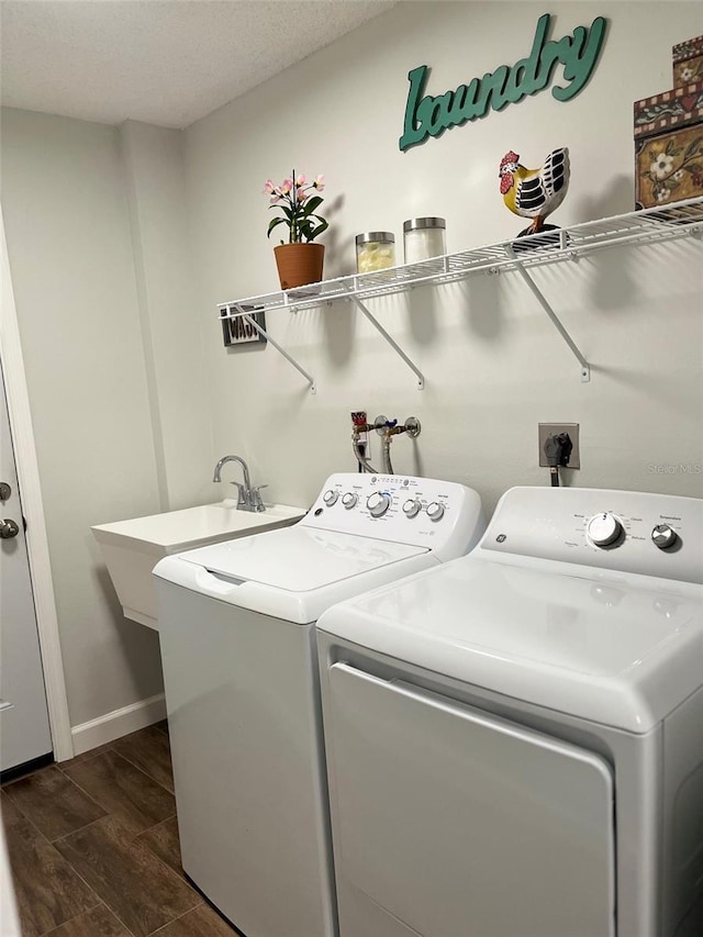 clothes washing area featuring washing machine and clothes dryer, baseboards, dark wood finished floors, and laundry area