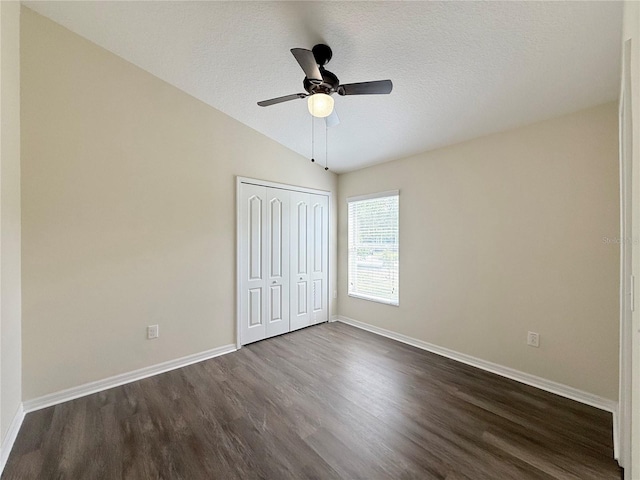 13181 Royal Pines Ave, Riverview, FL 33579 - unfurnished bedroom featuring dark wood-style flooring, lofted ceiling, baseboards, a closet, and a textured ceiling