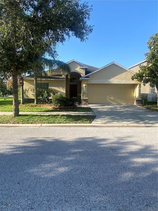 13181 Royal Pines Ave, Riverview, FL 33579 - view of front of property with a garage, stucco siding, and driveway