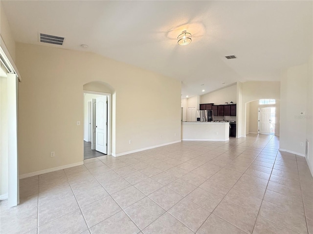 13181 Royal Pines Ave, Riverview, FL 33579 - unfurnished living room with vaulted ceiling, light tile patterned floors, arched walkways, and baseboards