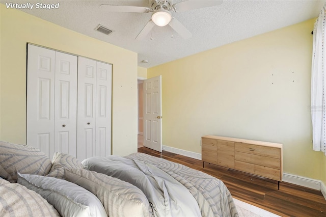 1515 12th Ct SE Unit 55, Largo, FL 33771 - bedroom featuring baseboards, dark wood-style flooring, a closet, ceiling fan, and a textured ceiling