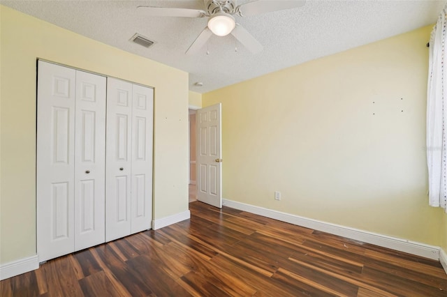 1515 12th Ct SE Unit 55, Largo, FL 33771 - unfurnished bedroom featuring dark wood finished floors, baseboards, a closet, a ceiling fan, and a textured ceiling