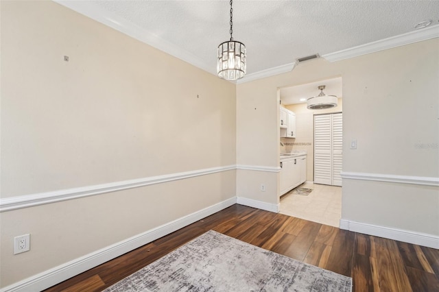 1515 12th Ct SE Unit 55, Largo, FL 33771 - spare room with a chandelier, wood finished floors, a textured ceiling, baseboards, and crown molding