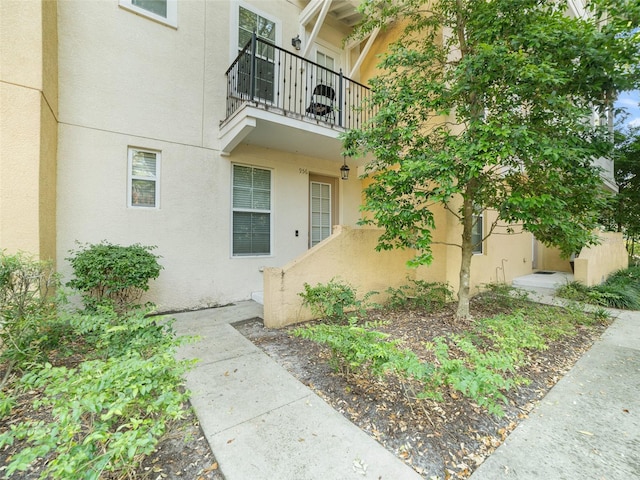 property entrance featuring stucco siding and a balcony