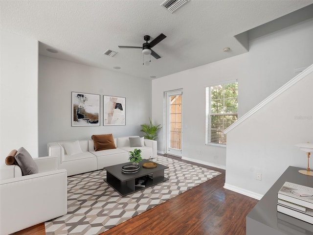 living area with a ceiling fan, baseboards, visible vents, and wood finished floors