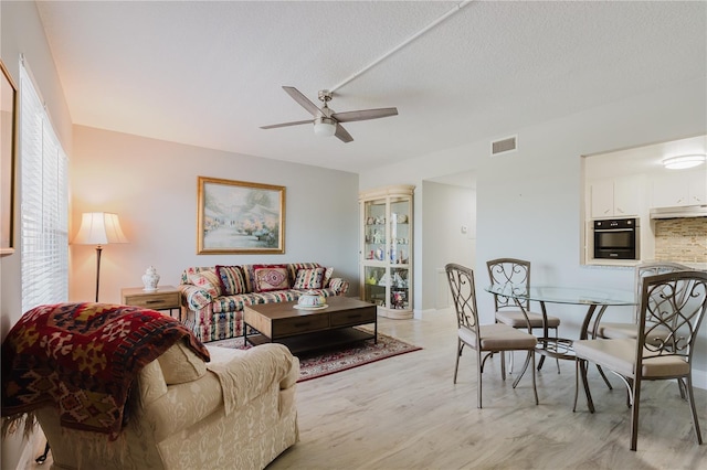 2457 Ecuadorian Way Unit 63, Clearwater, FL 33763 - living room featuring visible vents, a ceiling fan, light wood finished floors, and a textured ceiling