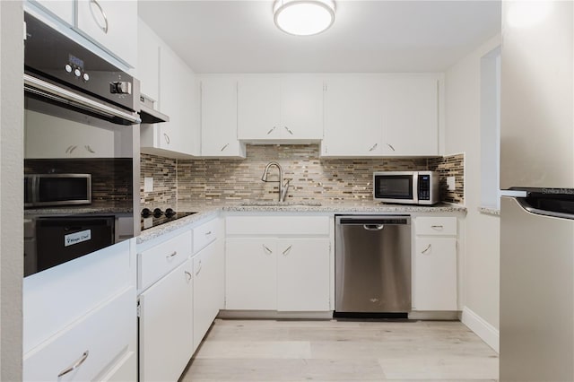 2457 Ecuadorian Way Unit 63, Clearwater, FL 33763 - kitchen featuring a sink, tasteful backsplash, light wood-style floors, and black appliances